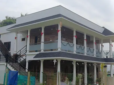 a large white building with a balcony at Eden Spot in Marayoor