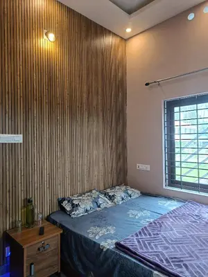 a bedroom with a bed and a wooden wall at Eden Spot in Marayoor