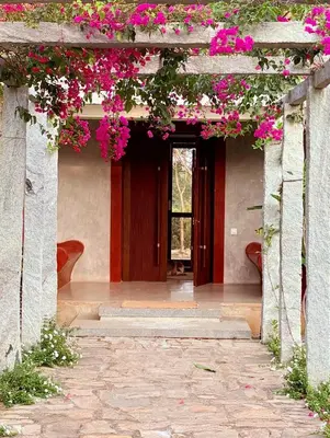 an entrance to a house with pink flowers at Chandra - Journey back to you in Honganūr