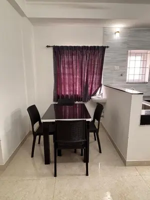 a dining room with a table and chairs and a window at Krish homes in Coimbatore