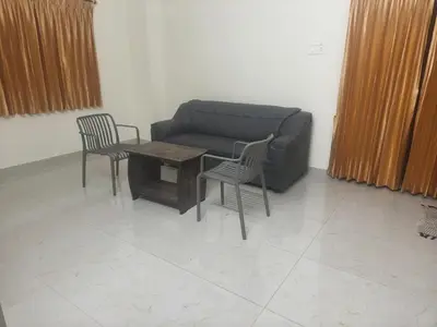 a living room with a couch and two chairs and a table at Nexus Living in Coimbatore
