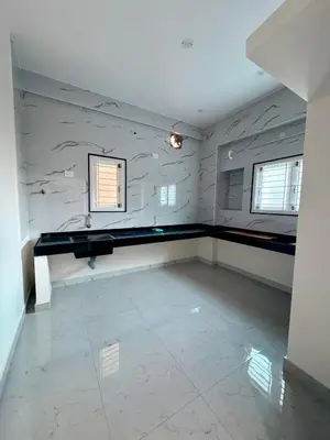 a empty room with a counter and two windows at Nexus Living in Coimbatore
