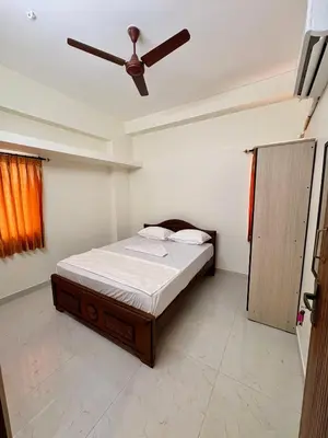 a bedroom with a bed with a ceiling fan at Nexus Living in Coimbatore