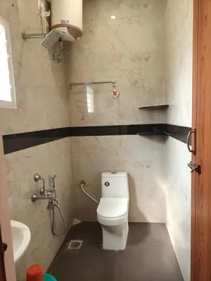 a bathroom with a toilet and a sink at Nexus Living in Coimbatore