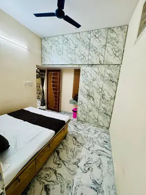 a bedroom with a bed and a marble wall at Flats in CITY Centre Next to Nexus Mall, 1km from bus stand in Mysore