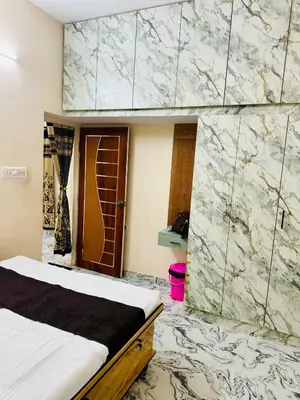 a room with a bed and a marble wall at Flats in CITY Centre Next to Nexus Mall, 1km from bus stand in Mysore