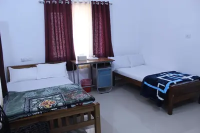 a hotel room with two beds and a window at Orchid Homestay in Viripara
