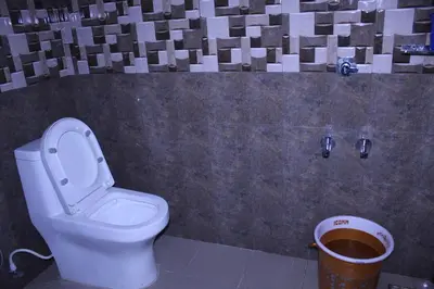 a bathroom with a toilet and a trash can at Orchid Homestay in Viripara