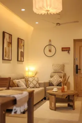 a living room with a couch and a clock on the wall at Nilgiri Breeze Apartment in Pīlamedu