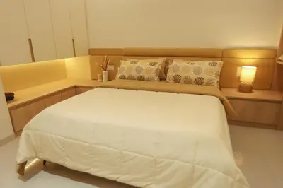 a bedroom with a large white bed in a room at Nilgiri Breeze Apartment in Pīlamedu