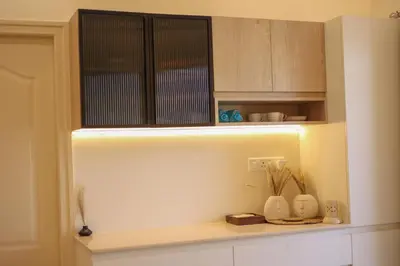 a kitchen with a shelf with vases on it at Nilgiri Breeze Apartment in Pīlamedu