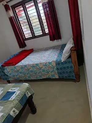 a bedroom with two beds and a window at Ananya Homestay in Napoklu