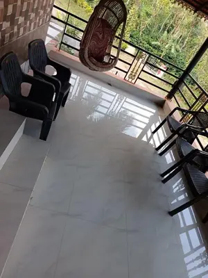 a living room with two chairs and a swing at Ananya Homestay in Napoklu