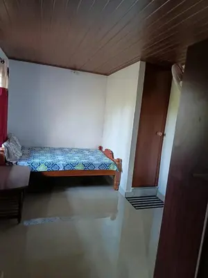 a small bedroom with a bed and a cabinet at Ananya Homestay in Napoklu