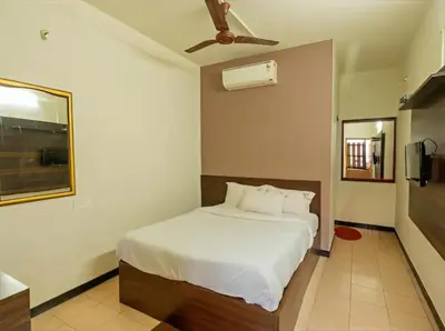 a bedroom with a bed and a ceiling fan at Royal Residency in Coimbatore