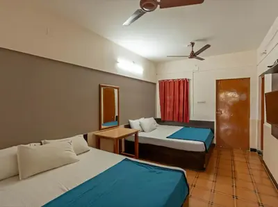 a hotel room with two beds and a ceiling fan at Royal Residency in Coimbatore