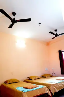 two beds in a room with two ceiling fans at BGF Residency - Cottage in Coimbatore