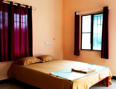a bed in a room with a window at BGF Residency - Cottage in Coimbatore