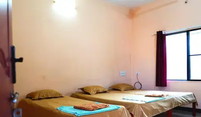 two beds sitting next to each other in a room at BGF Residency - Cottage in Coimbatore