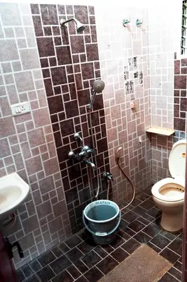 a bathroom with a shower with a toilet and a sink at BGF Residency - Cottage in Coimbatore