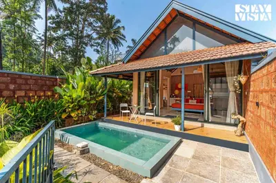 a home with a swimming pool and a house at StayVista at The Sattva Grove with Pool, Views in Wayanad