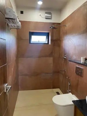a bathroom with a toilet and a window at Ozone The Misty Villa ooty ,Three Bed Room Luxury Private Jacuzzi Villa in Ketti