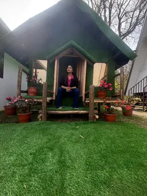 a woman sitting in a small house in a yard at Bethel resorts in Kanthalloor