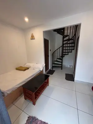 a room with two beds and a spiral staircase at Bethel resorts in Kanthalloor