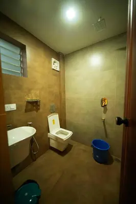 a bathroom with a toilet and a sink at Spezio Luxurious Apartments in Perintalmanna