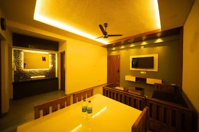 a dining room with a table with two bottles on it at Spezio Luxurious Apartments in Perintalmanna