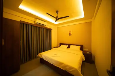 a bedroom with a bed with a ceiling fan at Spezio Luxurious Apartments in Perintalmanna