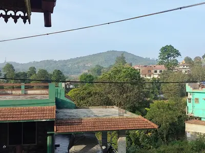a view of a city with mountains in the background at RajPari Stay in Madikeri