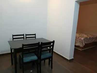 a dining room with a table and chairs and a bed at Willow Nest Cottages in Vattavada