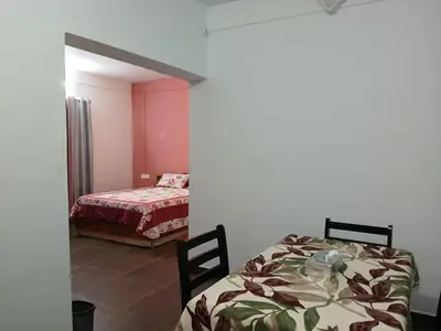 a room with two beds in a room with pink walls at Willow Nest Cottages in Vattavada