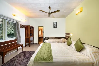 a bedroom with two beds and a piano at Jungle Hut Resort in Masinagudi