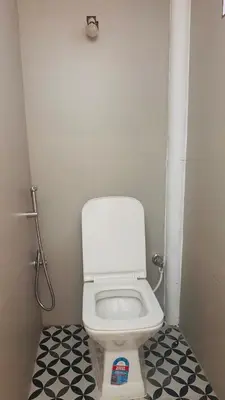 a bathroom with a white toilet in a stall at Nele Mane in Mysore