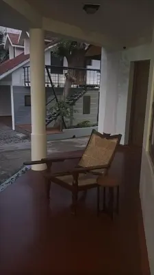 a wicker chair sitting on the porch of a house at Souparnika Heritage in Tellicherry