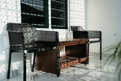 two chairs and a table in a room at Fenna Resort And Spa, coorg in Kushālnagar