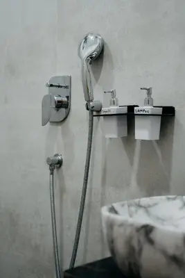 a bathroom with two faucets and a sink at Fenna Resort And Spa, coorg in Kushālnagar