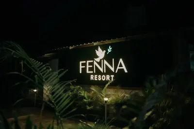 a sign for a fenina resort is lit up at night at Fenna Resort And Spa, coorg in Kushālnagar