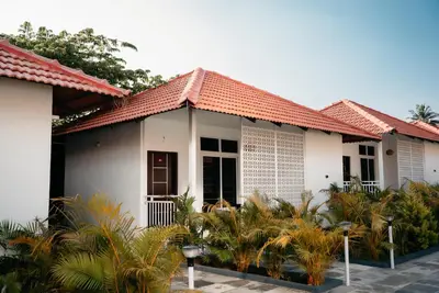 a house with a red roof and some plants at Fenna Resort And Spa, coorg in Kushālnagar