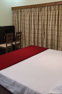 a bedroom with a bed and two chairs and a table at Kalariyullathil Homestay