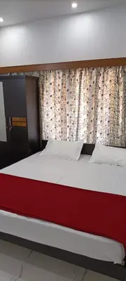 a bed in a bedroom with a red and white bed frame at Kalariyullathil Homestay