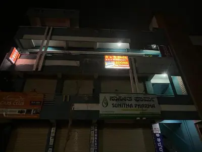 a building with signs on the side of it at night at D&D Residency in Mysore