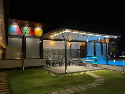 a house with a lit up patio at night at Aquatica Farms in Kodungallūr