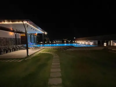 a night view of a building with a lawn and lights at Aquatica Farms in Kodungallūr