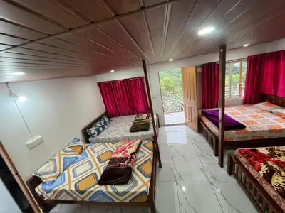 a room with two beds and a balcony at Joys Santa in Vattavada