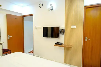 a bedroom with a mirror and a tv on a wall at 1 Bhk Luxury Flat in Samudhra Apartments -208 in Guruvāyūr