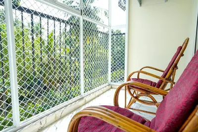 a porch with two rocking chairs and a large window at 1 Bhk Luxury Flat in Samudhra Apartments -208 in Guruvāyūr