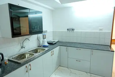 a kitchen with white cabinets and a sink at 1 Bhk Luxury Flat in Samudhra Apartments -208 in Guruvāyūr